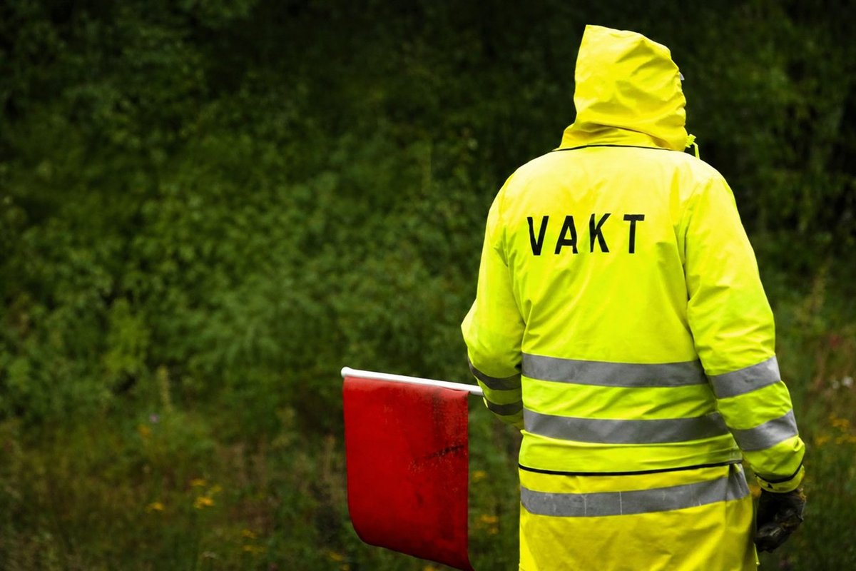 Flaggvakt som dirigerar trafiken vid ett vägarbete i Västerås